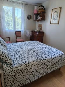 a bedroom with a bed with a blue and white blanket at Marie in Mignaloux-Beauvoir