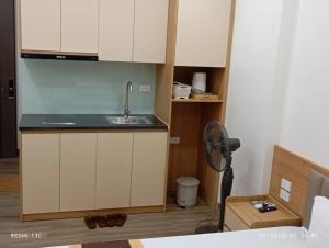 a kitchen with white cabinets and a sink and a fan at Nam Thanh Hotel in Nhật Tựu +8 photos