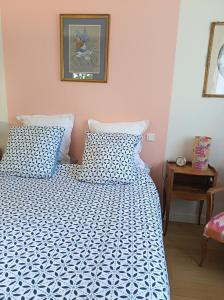 a bed with a blue and white comforter in a bedroom at Marie in Mignaloux-Beauvoir +4 photos