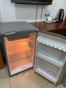 a small refrigerator with its door open in a kitchen at Lunar Stay HCM in Ho Chi Minh City