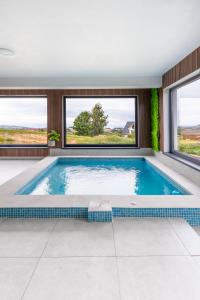 a swimming pool in a house with windows at Panoramic Hill Jina in Jina