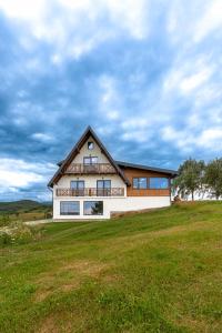 a house on top of a grassy field at Panoramic Hill Jina in Jina