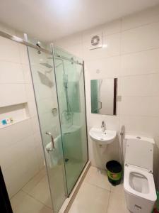 a bathroom with a shower and a toilet and a sink at Lagos Airport Hotel in Ikeja
