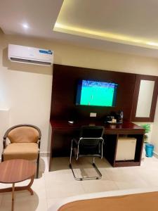 a living room with two chairs and a television on a wall at Lagos Airport Hotel in Ikeja