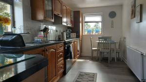 a kitchen with wooden cabinets and a table in it at The Smithy at 52 Vatisker in Stornoway