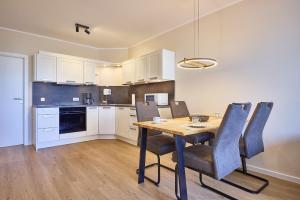 a kitchen with a wooden table and chairs in a room at Haus Schildt, FeWo 1 in Duhnen