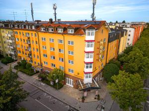 a group of yellow buildings on a city street at Park Hotel Laim Serviced Apartments in Munich