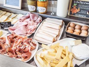 a counter with different types of meats and cheese at Mercure Belfort Centre in Belfort