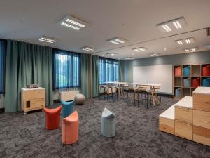a conference room with tables and chairs and windows at Mercure Parkhotel Mönchengladbach in Mönchengladbach