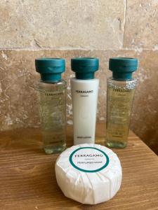 three bottles of sunscreen sitting on top of a wooden table at Pietra Museum Suites Sirolo in Sirolo +15 photos