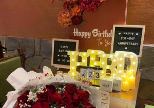 a table with flowers and candles and a bouquet of roses at Amsphere Homestay & Restaurant in Hanoi +67 photos