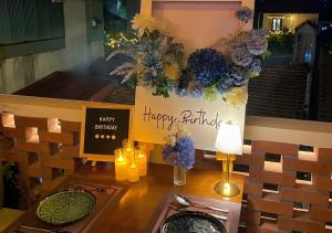 a table with a happy birthday sign and flowers at Amsphere Homestay & Restaurant in Hanoi