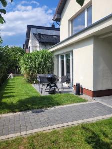 a patio with a picnic table next to a house at BŁĘKITNA 37 apartamenty in Kołobrzeg