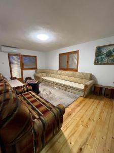a living room with a large couch and wooden floors at Relax home in Travnik