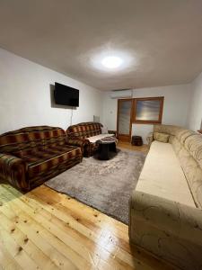 a living room with two couches and a flat screen tv at Relax home in Travnik