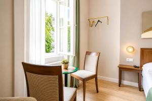a room with a table and two chairs and a window at 1 Aprt & 5 Stylish Hotel Rooms, Comfort & Convenience Combined in Vienna