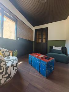 a living room with a couch and a blue ottoman at La Bulle Carrée - Centre Historique médiéval - in Lapalme