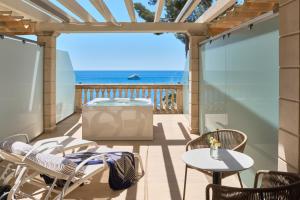 a patio with chairs and a grill and the ocean at Barceló Illetas Albatros - Adults Only in Illetas