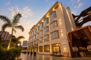 a large building with palm trees in front of it at The Aura Hotel & Resort in Noida