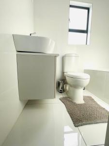 a white bathroom with a sink and a toilet at MAISON MOSH ll GUEST HOUSE in Maseru +48 photos