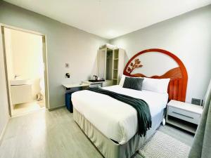 a bedroom with a large bed and a large window at MAISON MOSH ll GUEST HOUSE in Maseru