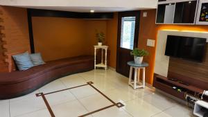 a living room with a couch and a flat screen tv at Vayal Heritage Villa in Angamaly