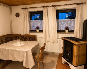 a dining room with a table and two windows at U krbu in Jindřichovice