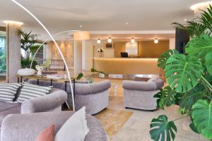 a lobby with couches and plants and a counter at Barceló Illetas Albatros - Adults Only in Illetas