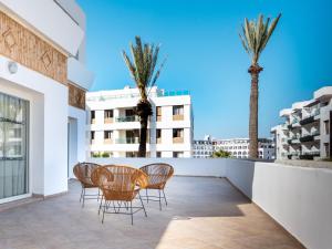 a balcony with a table and chairs and palm trees at Intouriste Hotel & Suites in Agadir