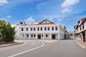a white building on the side of a street at Swiss Heritage Boutique Hotel Jonker Street Melaka in Malacca