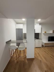 a kitchen with a counter and two stools and a table at El Gabal in Soto de la Marina +12 photos