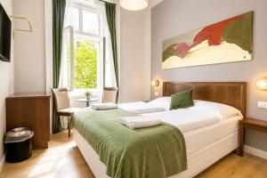 a bedroom with a bed with a green blanket at 1 Aprt & 5 Stylish Hotel Rooms, Comfort & Convenience Combined in Vienna