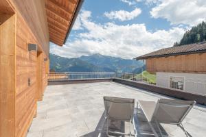 a balcony with two chairs and a view of the mountains at Chalet Ahornblick in Mühlen