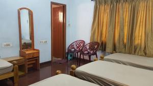 a bedroom with two beds and a mirror and two chairs at GokStay in Chennai