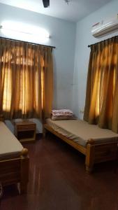 a room with two beds in a room with curtains at GokStay in Chennai