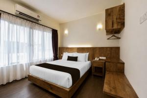 a bedroom with a large bed and a window at Swiss Heritage Boutique Hotel Jonker Street Melaka in Malacca