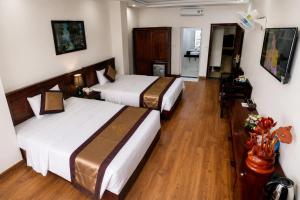 two beds in a hotel room with wooden floors at Mama Cao Bang Hotel in Cao Bằng +6 photos