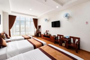 a hotel room with three beds and a flat screen tv at Mama Cao Bang Hotel in Cao Bằng