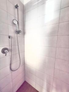 a shower in a bathroom with white tiles at Dream holiday in Mestre