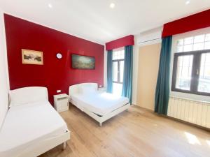 a bedroom with two beds and a red wall at Dream holiday in Mestre +31 photos