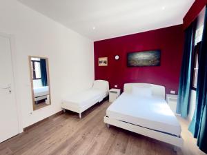 a bedroom with two beds and a red wall at Dream holiday in Mestre