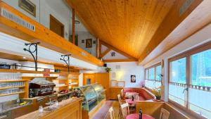 a large kitchen with wooden ceilings and wooden counters at Baita dei Pini in Campodolcino