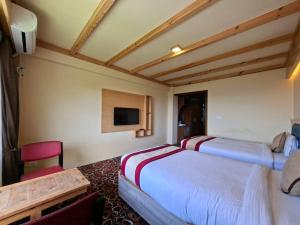 a hotel room with two beds and a tv at Landmark Diamond Hill in Panaoti