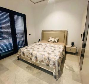 a bedroom with a bed and a large window at Résidence Mariem Tantana in Akouda