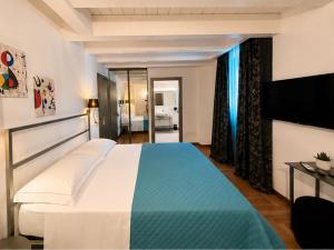 a bedroom with a large bed and a television at SiRiuS rooms & charme in Villasimius +59 photos