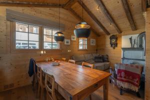a dining room with a wooden table and a couch at Rumpelstilzchen in Bettmeralp