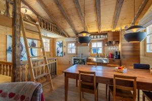 a kitchen and dining room with a wooden table and chairs at Rumpelstilzchen in Bettmeralp