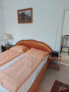 a bed in a bedroom with a picture on the wall at Tapolca Centrum-Tapolca Szíve Apartmanok in Tapolca