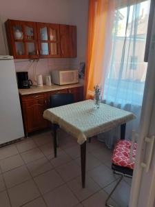 a small kitchen with a table and a microwave at Tapolca Centrum-Tapolca Szíve Apartmanok in Tapolca