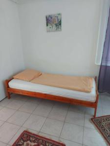 a small bed in a room with two rugs at Tapolca Centrum-Tapolca Szíve Apartmanok in Tapolca +3 photos